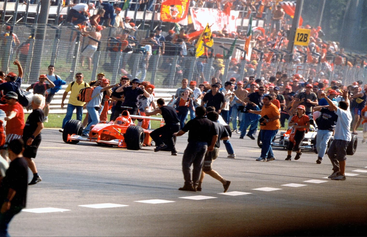 tifosi celebrate around michael schumacher's formula one car