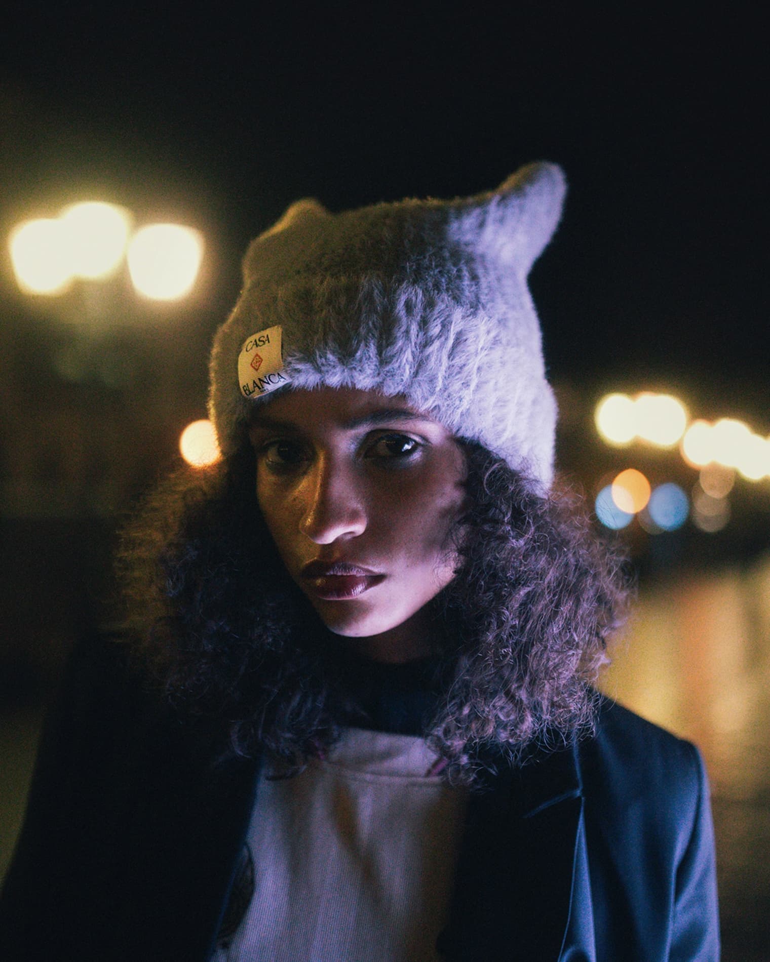 Woman wearing Casablanca square hat, Ganni blazer and Nike long sleeved jersey.