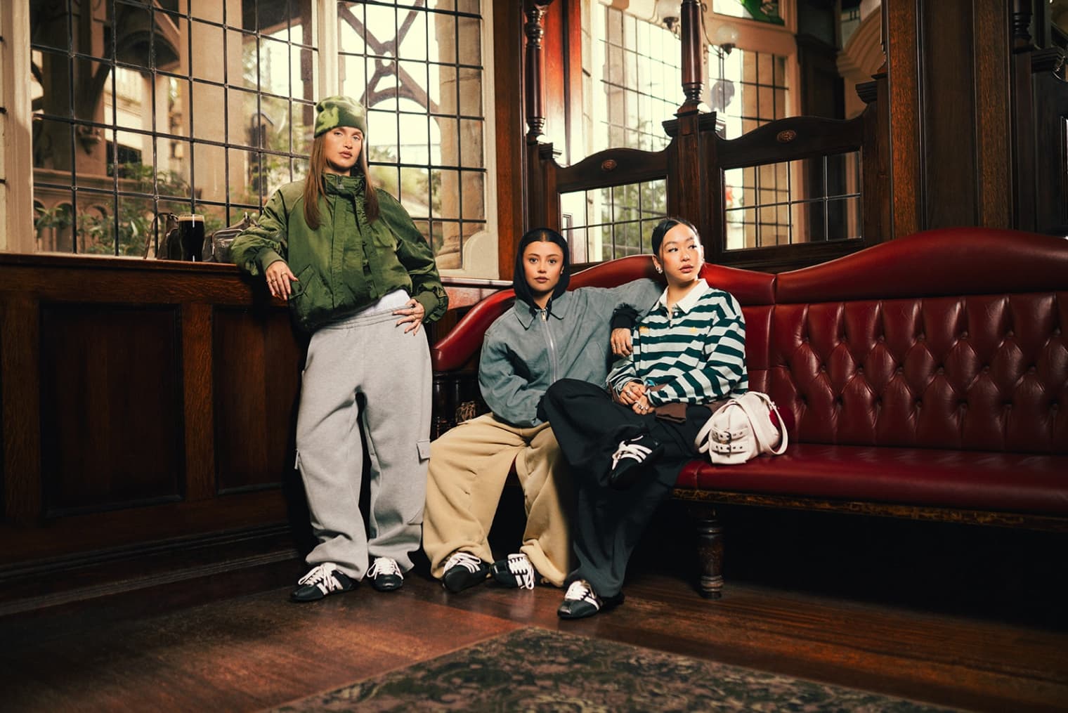 Three women wearing the end Adidas Tokyo black and white sneaker, in a pub.