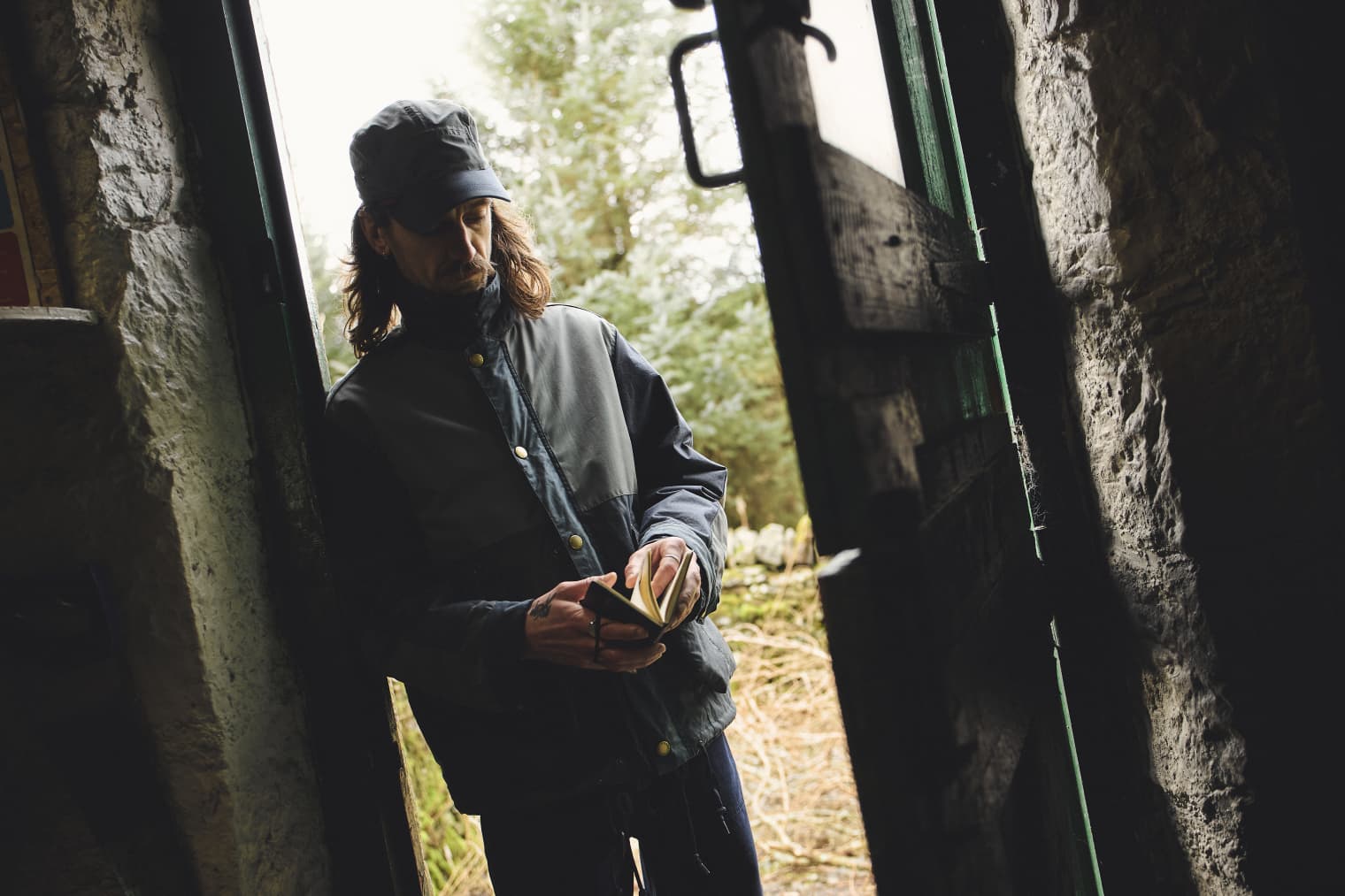 A man standing in the doorway holding a notepad.