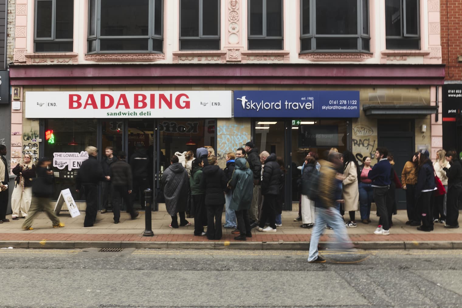 The exterior of a shop called Bada Bing, with a large group of people queuing up to enter. 
