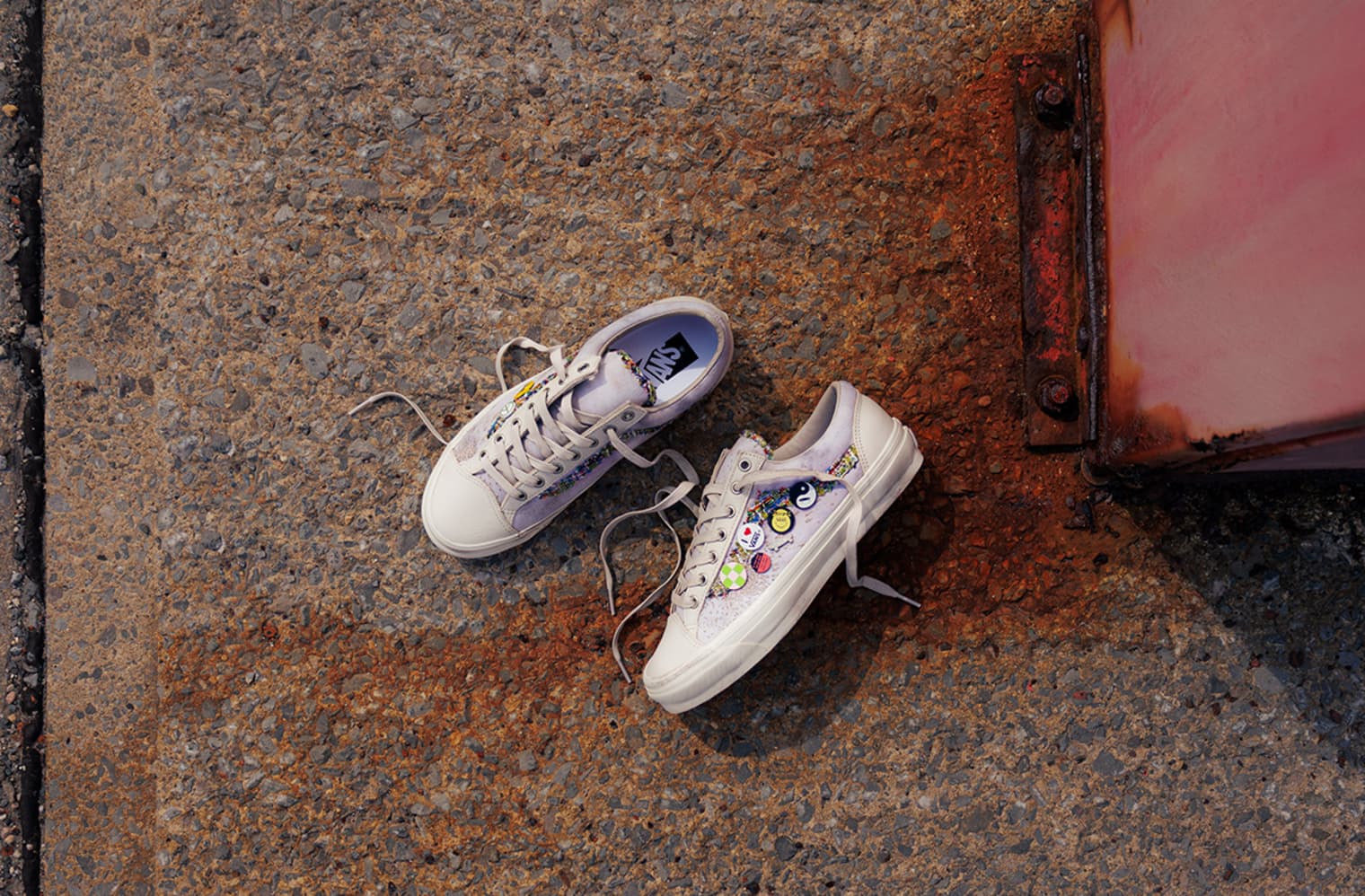 Vans Old Skools with badges lying on the ground