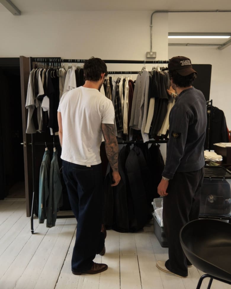 Daniel Simmons looks through a rack of clothes in his studio