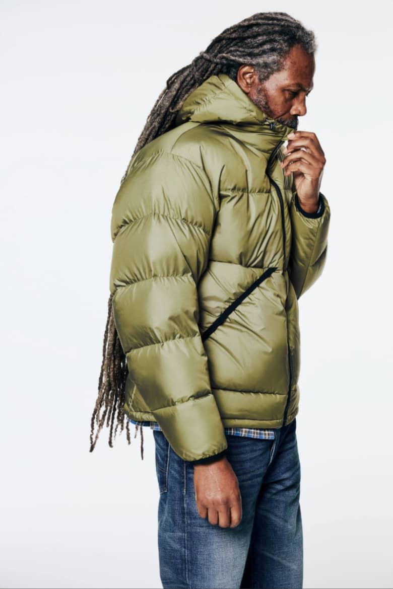 A model wears a Gramicci Down Jacket