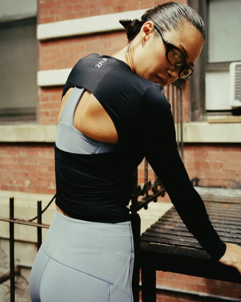 A woman wears Bandit running jacket, vest, and shorts