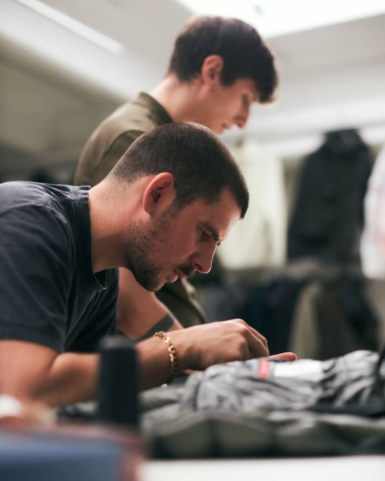 Artisans work on clothing in a workshop
