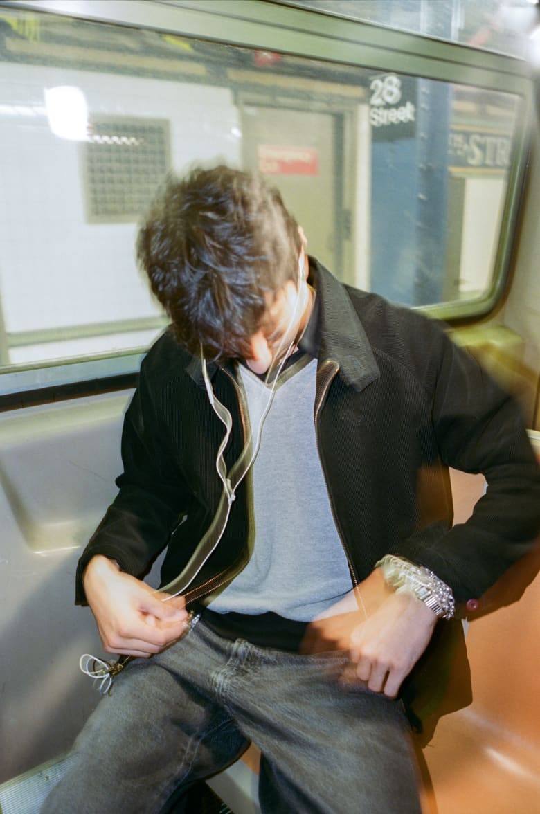 A man on a subway adjusting his clothing. 