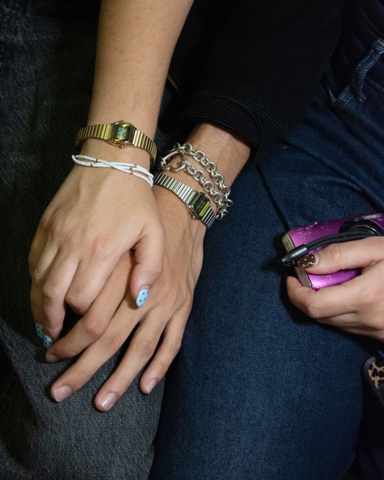 A close up of two people holding hands, with Timex watches on their wrists. 