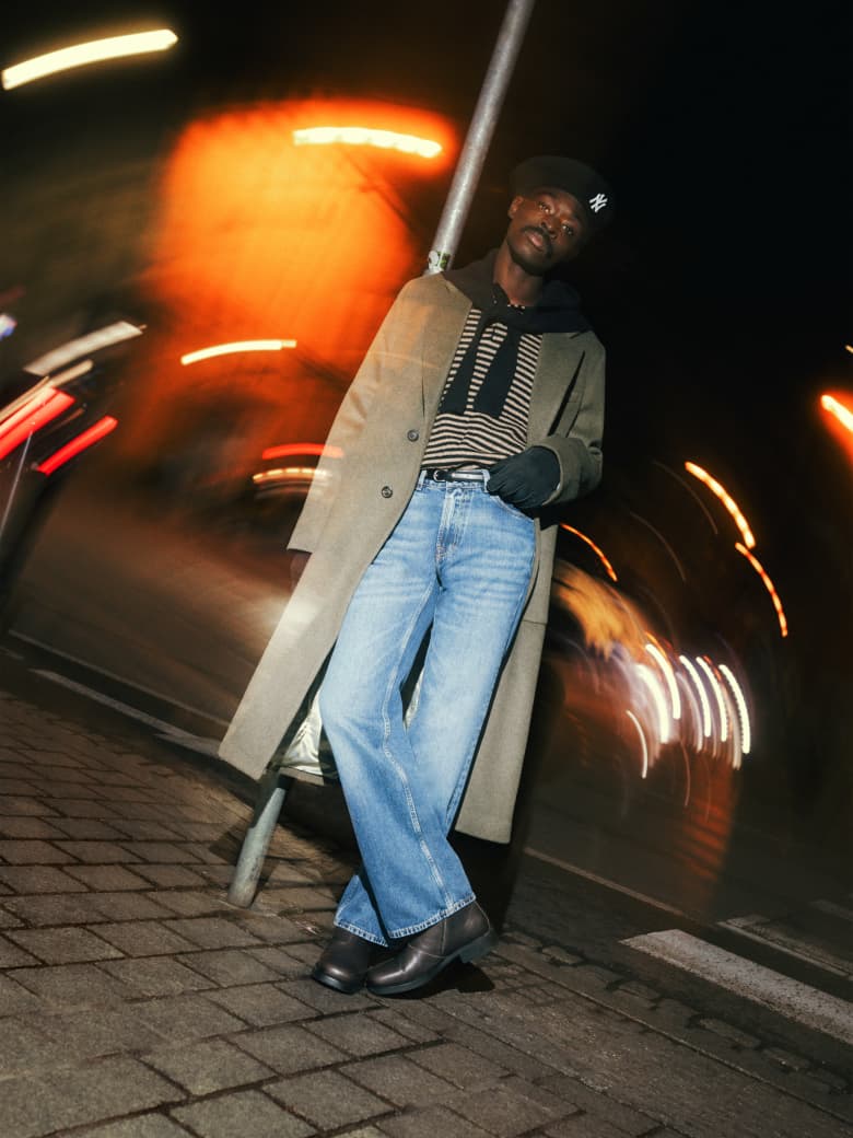A man wearing Our Legacy coat, Carter Young jumper, Jacquemus scarf, Hestra gloves and New Era beret.
