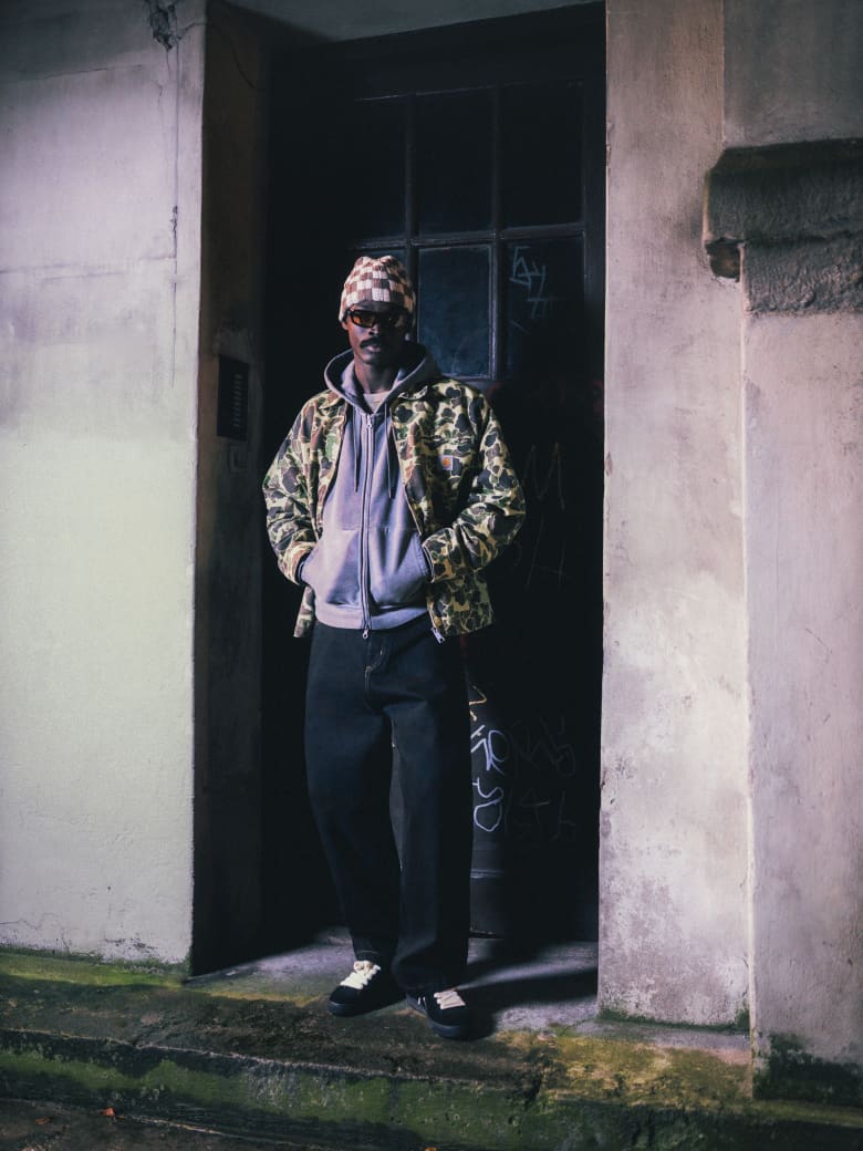 A man wearing Carhartt WIP jacket, Our Legacy hoodie, END. x Puma sneakers and Le Specs sunglasses.
