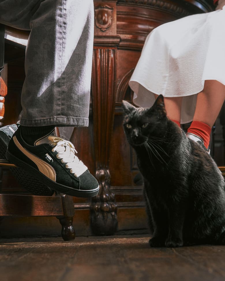 Two people wearing the end Puma speedcat and suede sneakers in black and white.