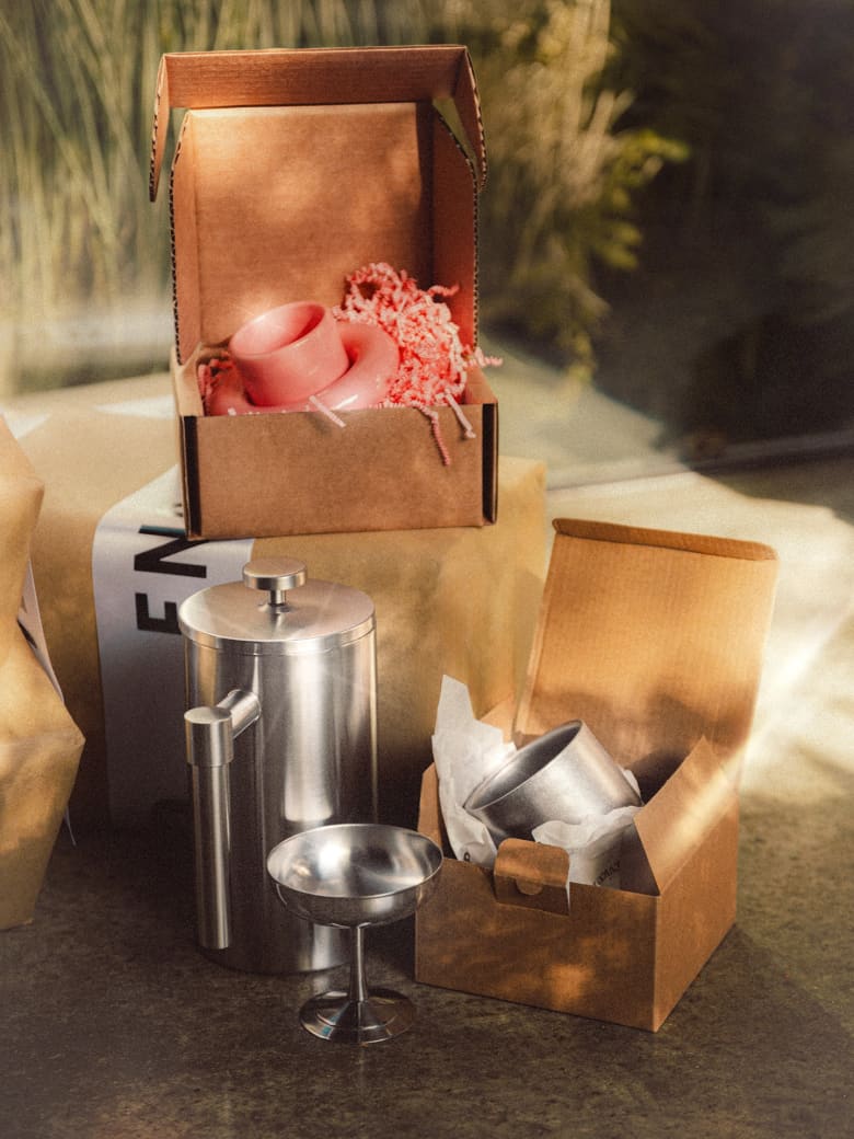 Wrapped present boxes holding Hay products, and the Service Projects stainless steel french press. 