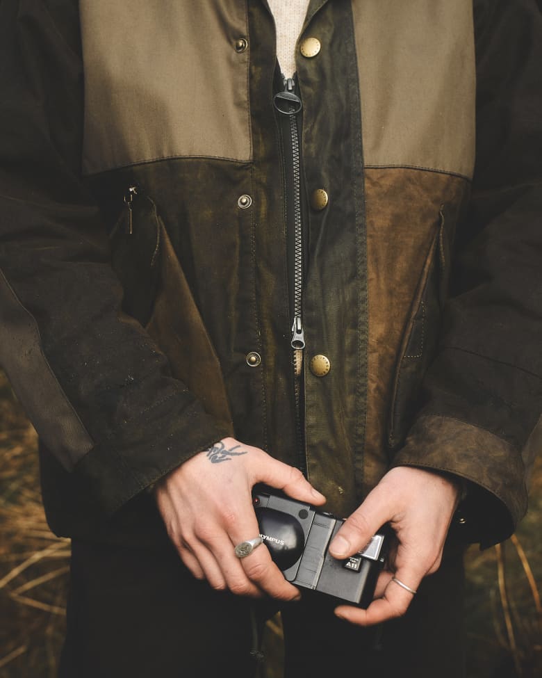 A close up of hands holding a film camera.