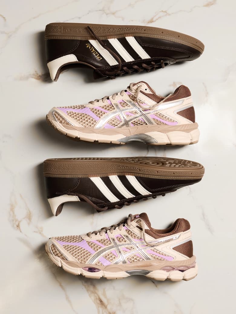 Three sneakers are laid on their sides against a marble backdrop.