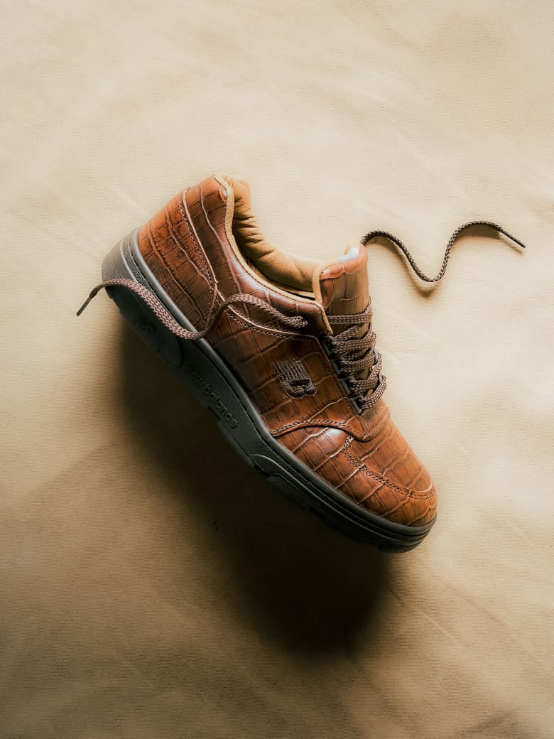 A brown leather sneaker placed on the floor. 