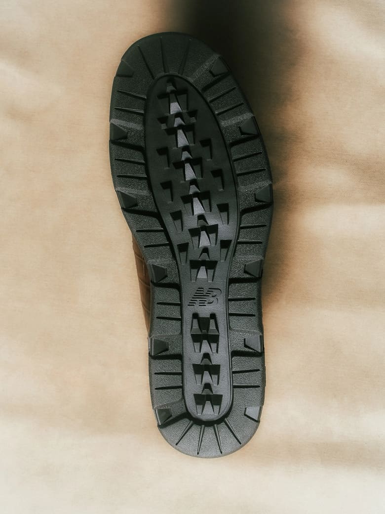 The sole of a brown leather trainer.