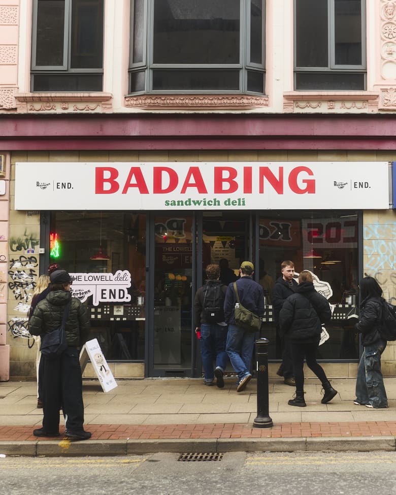The exterior of a shop called Bada Bing, with a group of people entering.