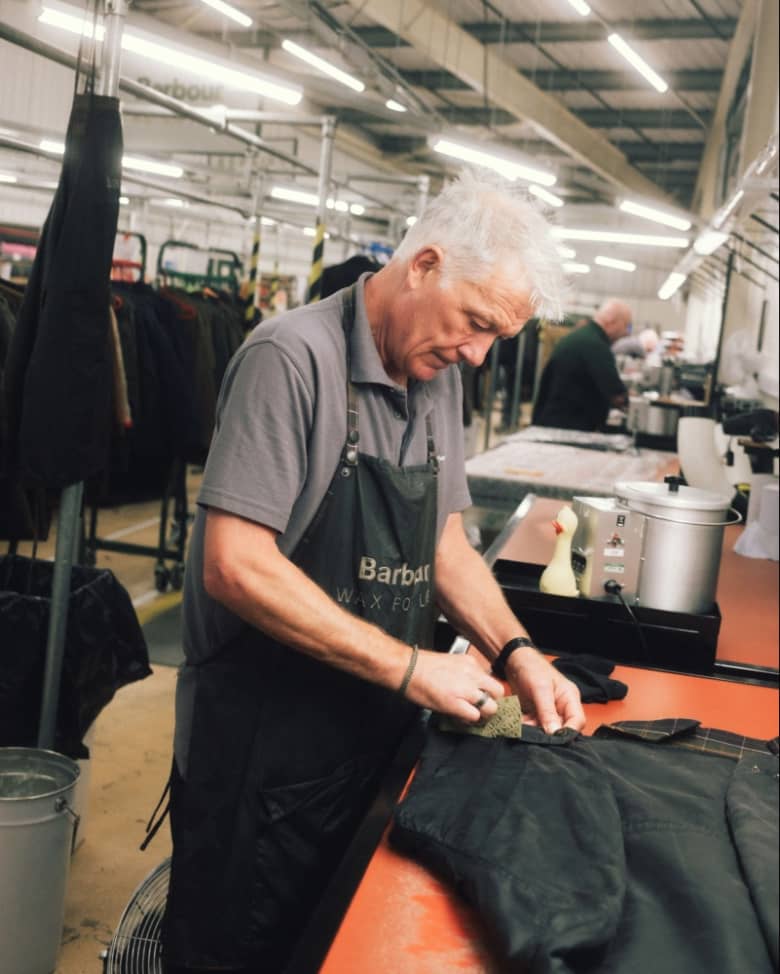 A man repairs a Barbour Jacket at the factory