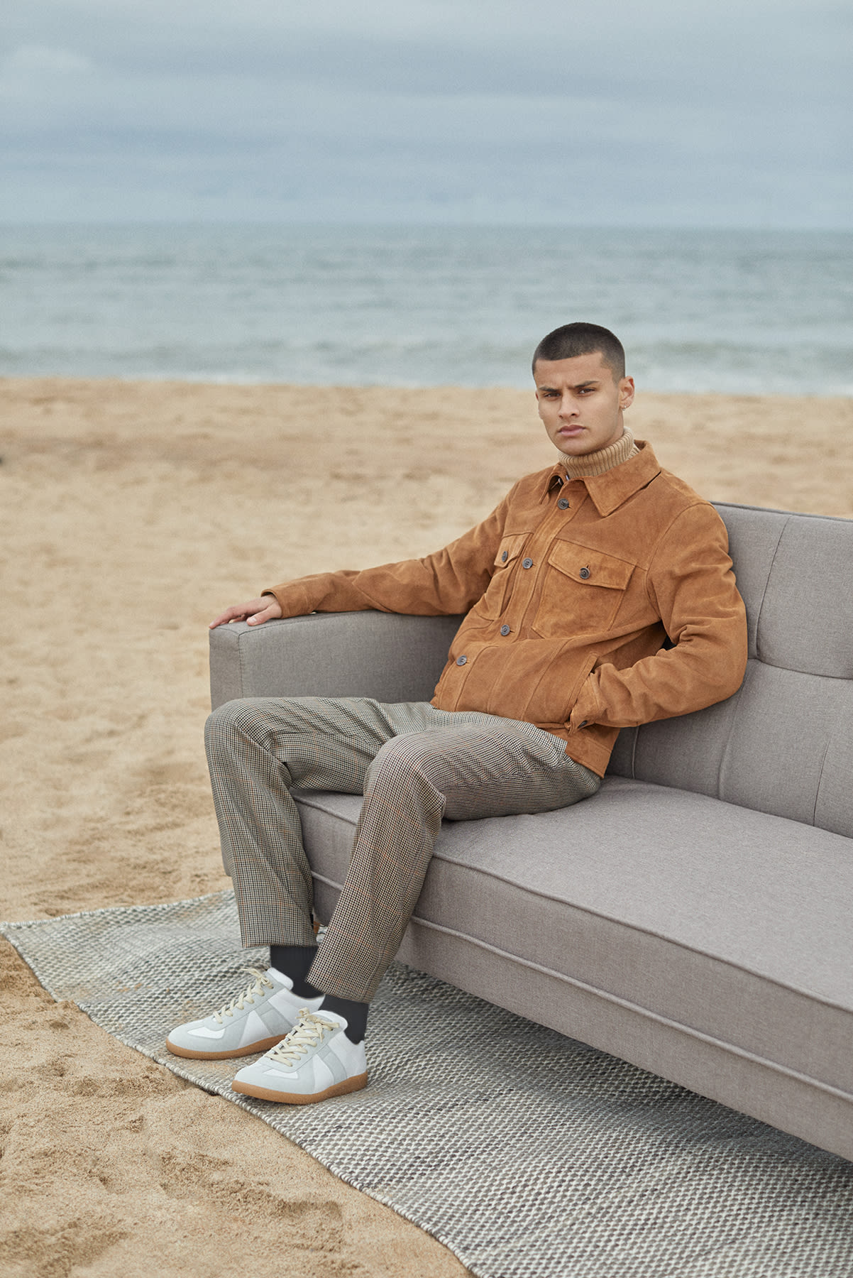 Suede A.P.C. jacket worn for Bare Minimum END. editorial on sofa at the beach