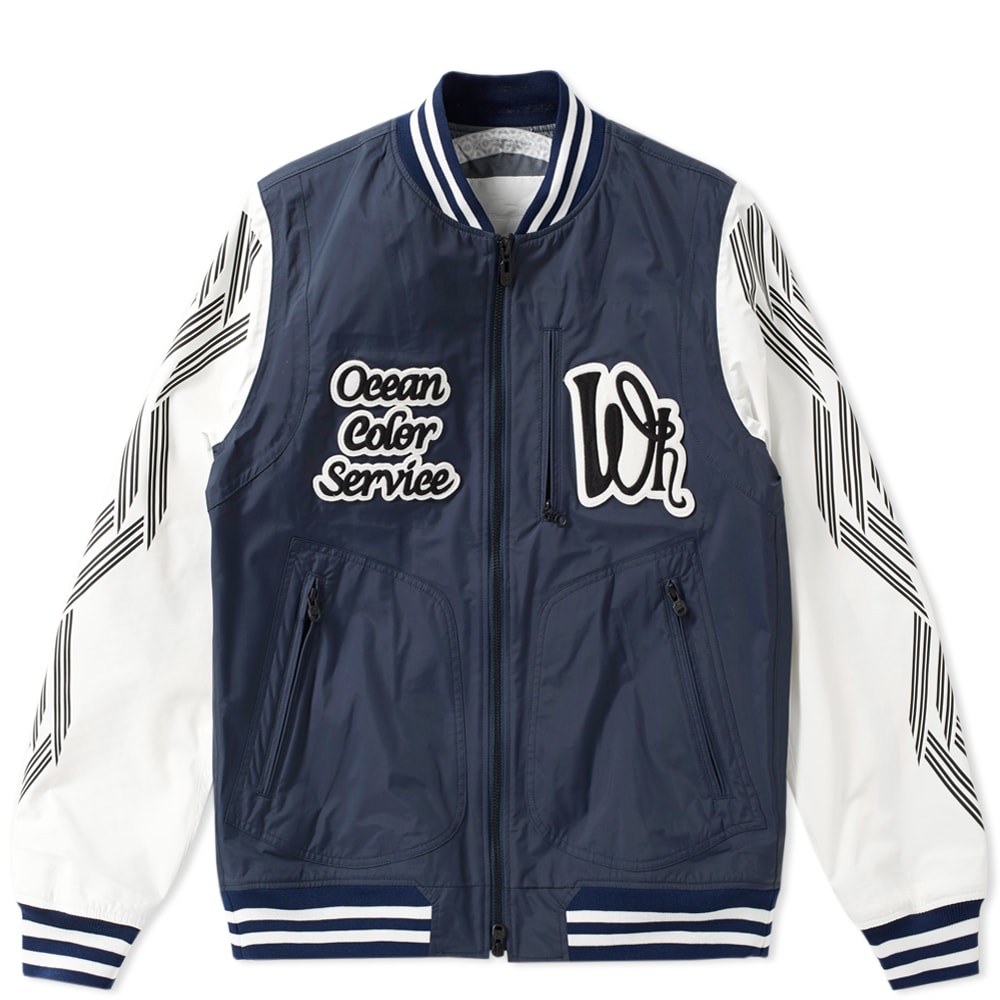 As Yosuke Aizawa sent a collection of colourful graphics, tropical prints and jungle illustrations down the runway, a statement bomber emerged out of the smoke and into the neon lights. Crafted from a waterproof and breathable Saitos nylon shell, White Mountaineering explored nautical adventure novels and marine navy colourways for SS17. Decorated with the brand’s logos throughout, the ‘Ocean Color Service’ applique pays homage to this seasons themes, while being constructed with design, utility and technology as a nod to the Japanese label’s primary notion.

100% Nylon
Breathable, Waterproof & Laminated
Ribbed Collar, Cuffs & Hem
Side Zip Pockets
Chest & Back Appliques
Made In Japan