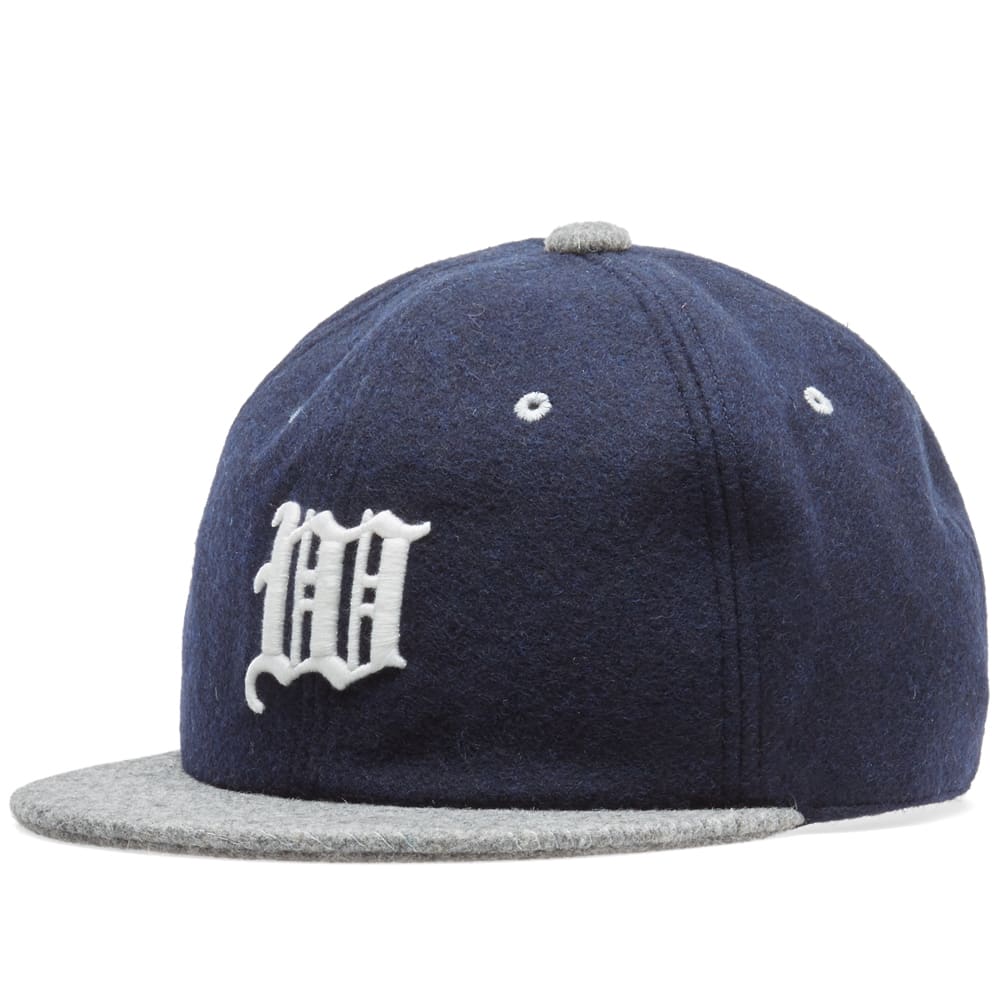 White Mountaineering's reputation for creating superior outdoor clothing, expertly made to the highest possible level. All pieces the brand produce must meet their three core principles: design, utility and technology.For this new take on the classic six panel baseball cap White Mountaineering utilize a sturdy wool cloth in two contrasting shades. The front panels are emblazoned with an elaborate 'W' embroidery whilst the back is finished with a suede strap.

Wool Construction
6 Panel Design
Embroidered Logo
Adjustable Suede Strap
Made In Japan