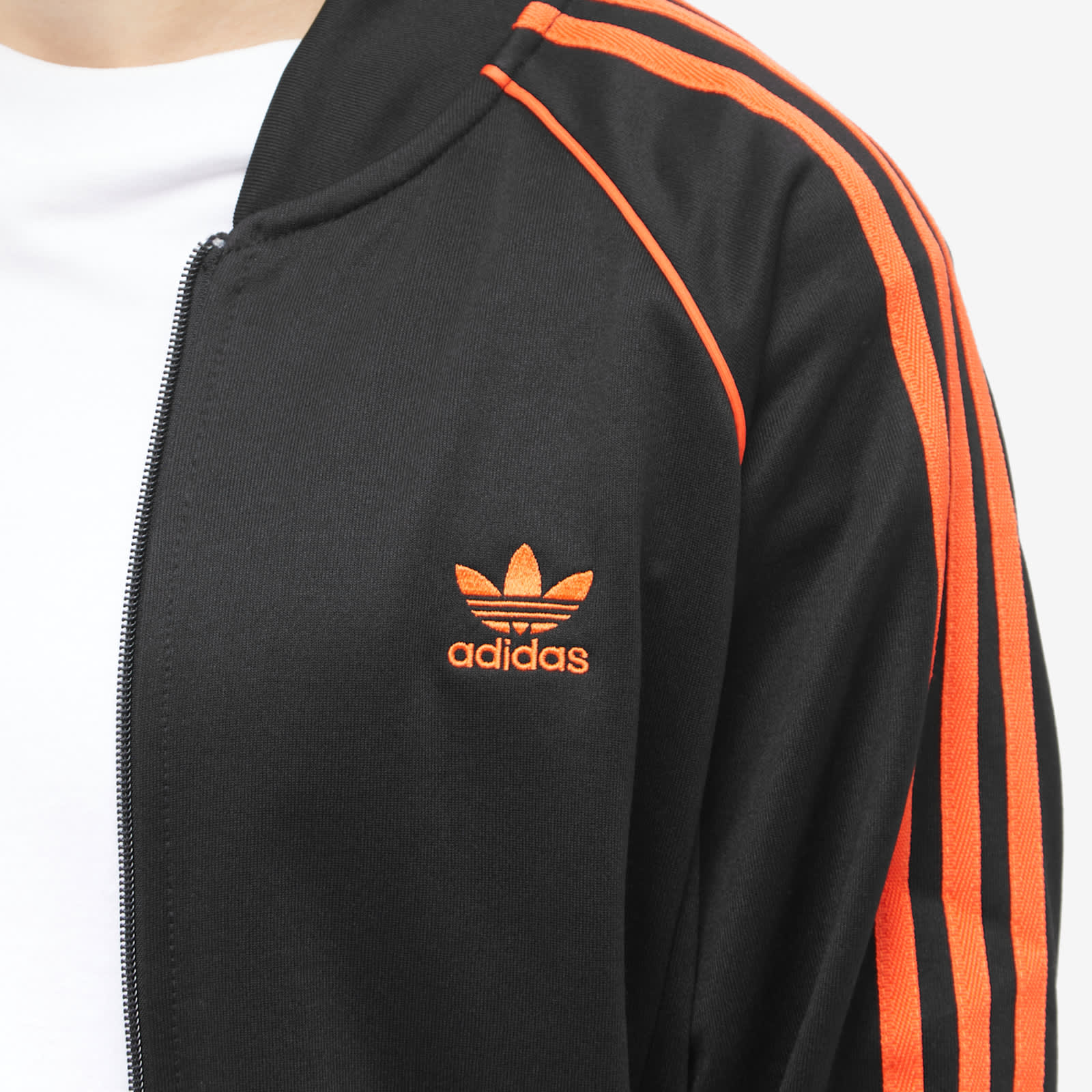 black and orange adidas superstars